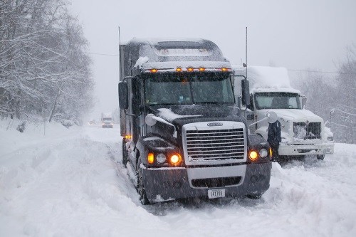 Trucks in snow illustrating highway freight transportation.